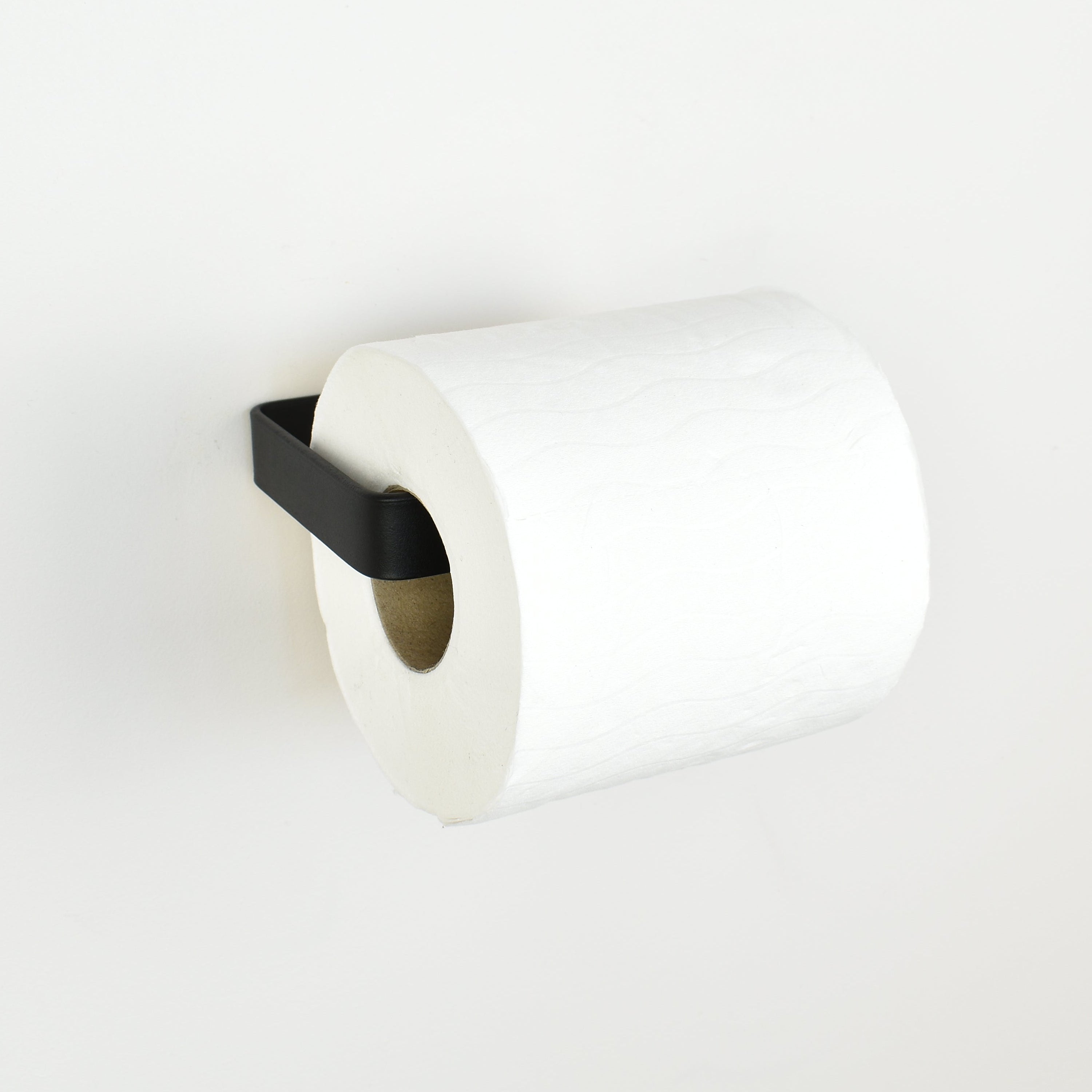Black metal toilet paper holder left view showing toilet roll in place