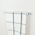 Metallic silver towel holder with white towel displayed - modern industrial bathroom decor and storage solution