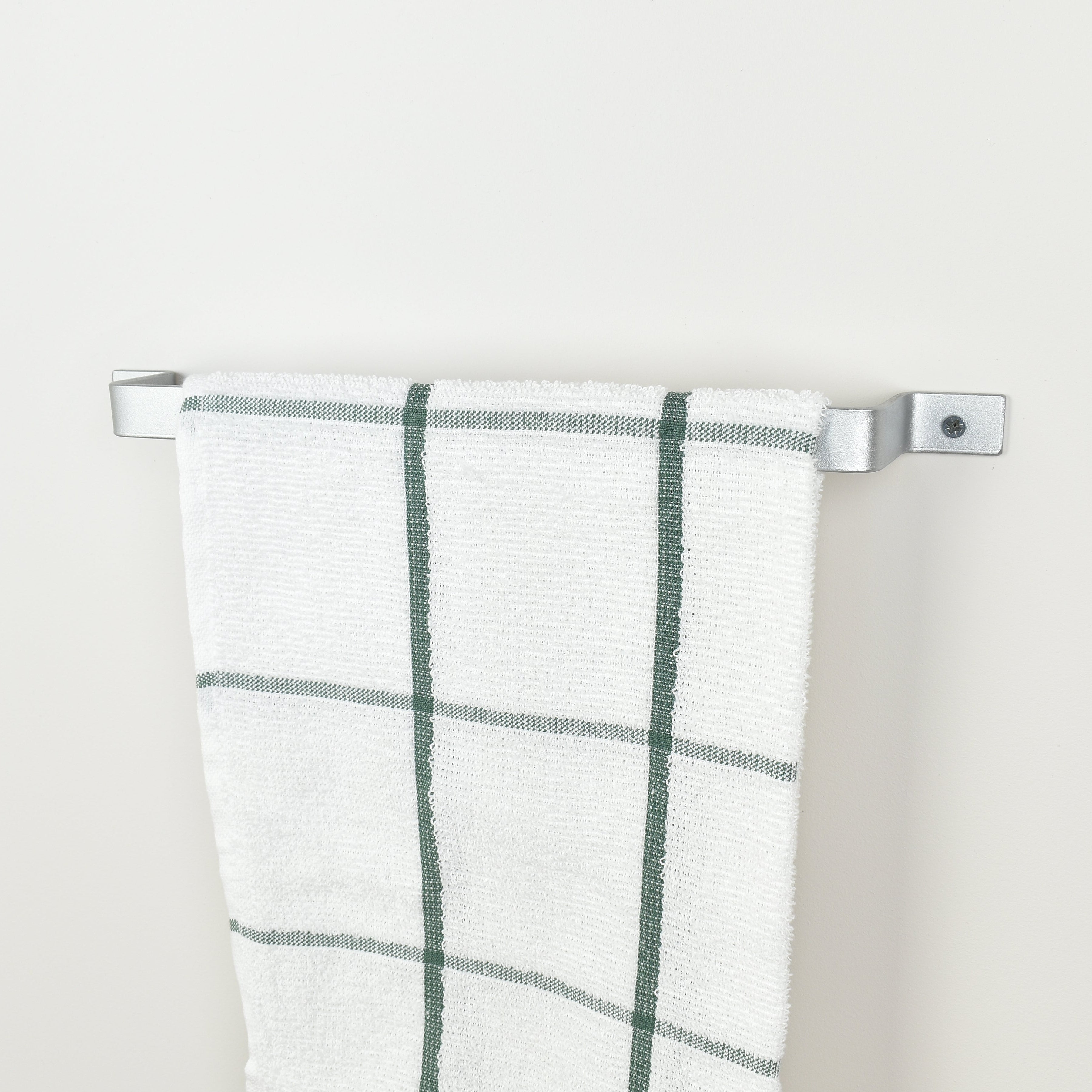 Metallic silver towel holder with white towel displayed - modern industrial bathroom decor and storage solution