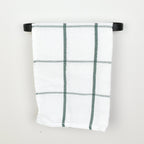 Plaid towel hanging on a black towel rack against a white background - front view