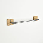 metal towel rack with oak brackets on a white wall
