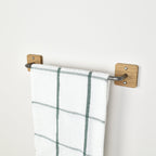 oak and pewter metal towel rack with a plaid towel on a white wall