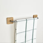 oak and pewter steel towel rack with a plaid towel on a white wall setting