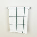 Plaid towel hanging on a silver towel rack against a white background - front view