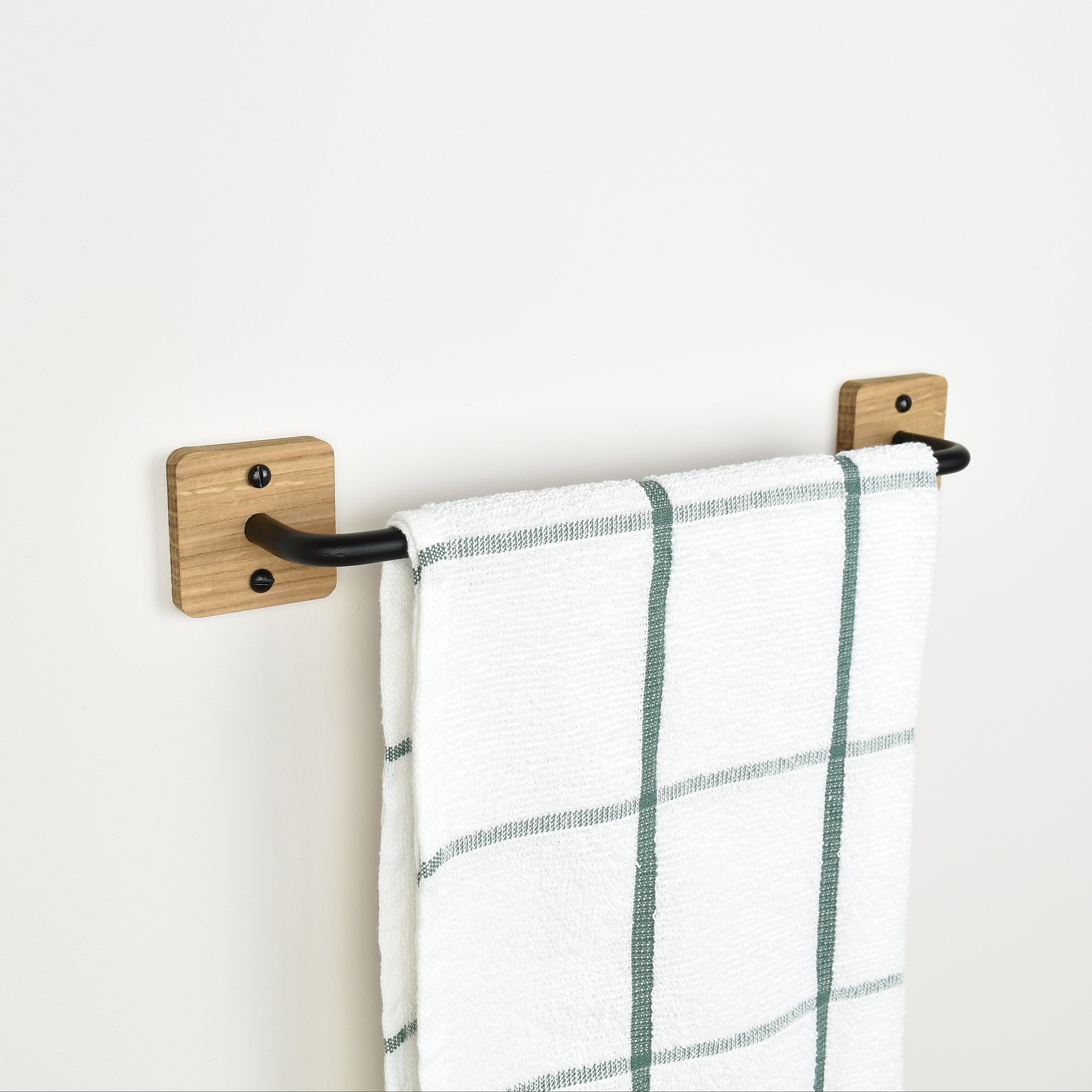 oak and black steel towel rack with a towel on a white wall setting