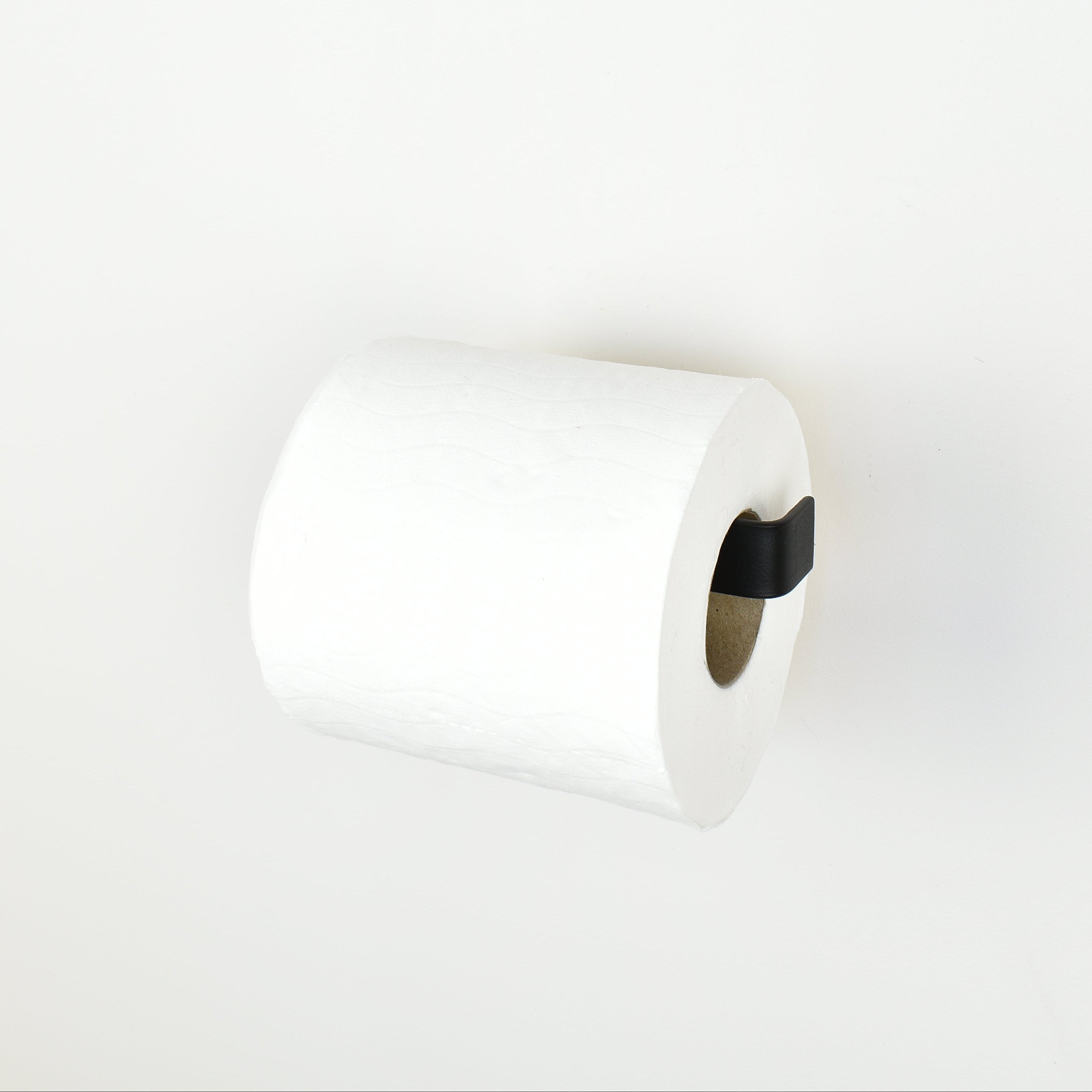 roll of toilet paper on a matte black steel toilet roll holder - right view