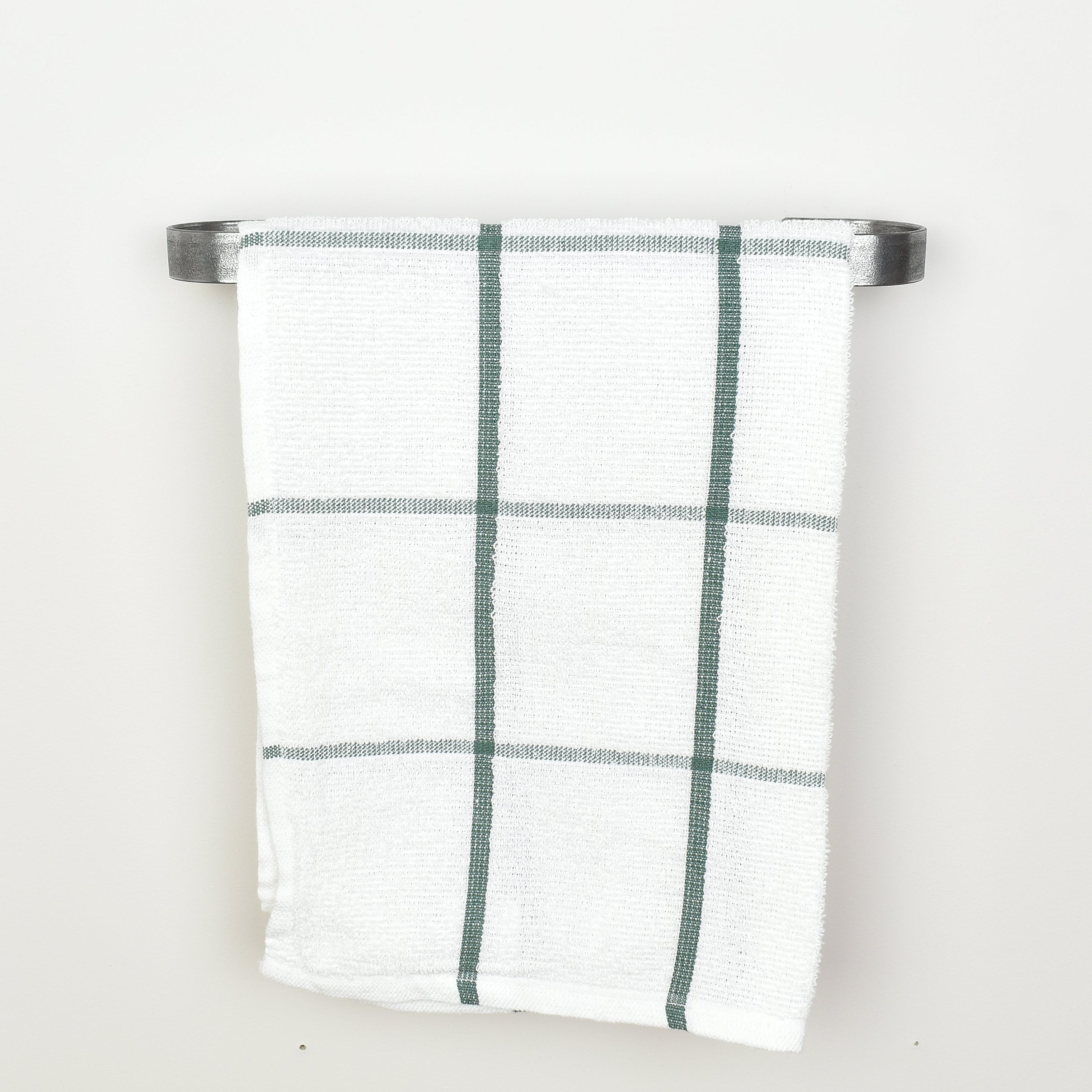 Plaid towel hanging on a pewter towel rack against a white background - front view