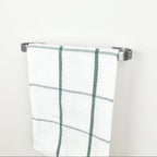 Plaid towel hanging on a pewter towel rack against a white background - right view