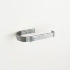 rounded edge pewter metal toilet roll holder with a white background - left view