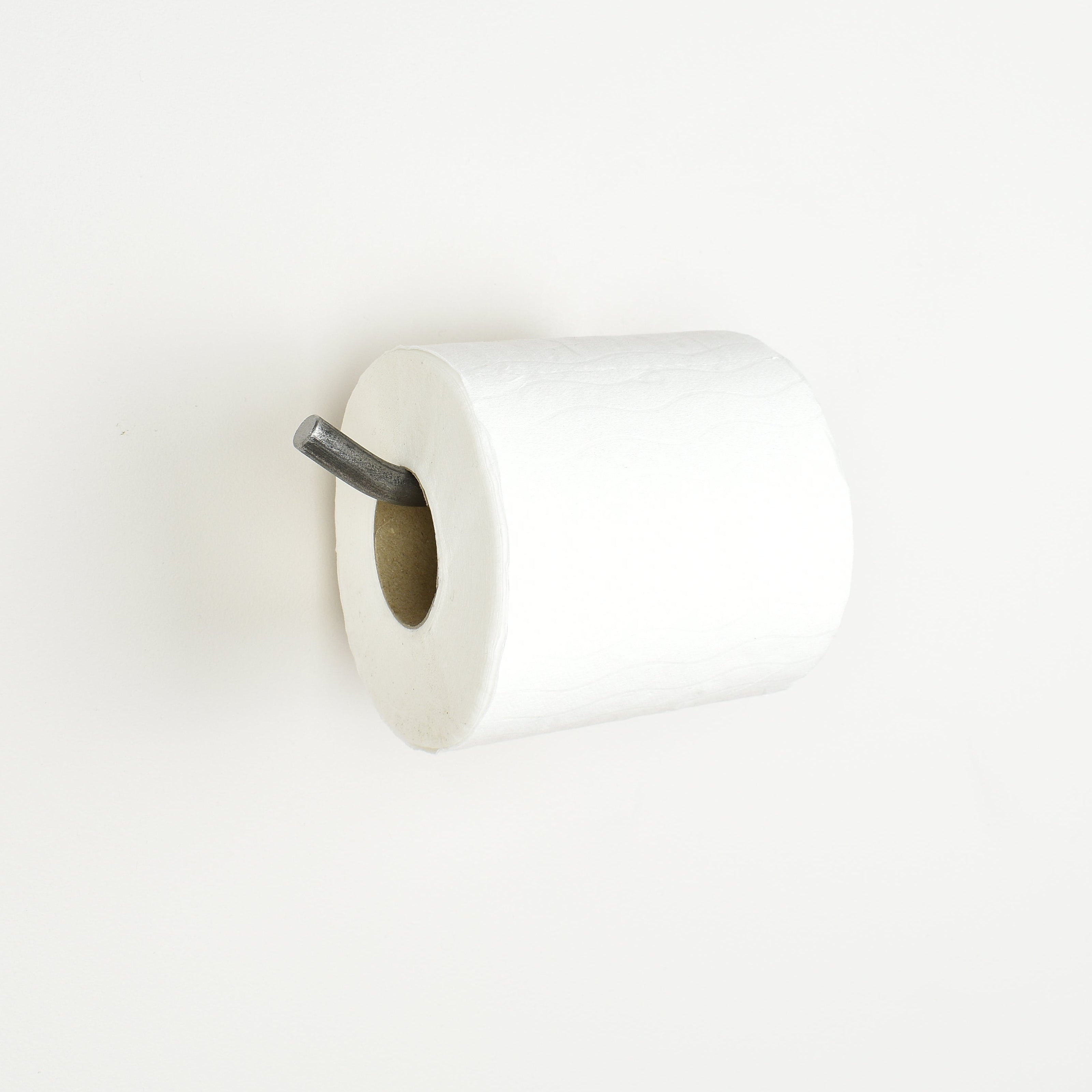 white toilet paper on a pewter toilet roll holder bar with a white background