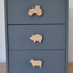 Oak farm animal drawer knobs fitted to a chest of drawers showing tractor, pig and sheep designs