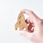 Hand holding handmade oak rocket drawer knob showing raised window detail and natural wood grain