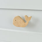 Oak whale drawer knob fitted to a white chest of drawers showing natural wood grain