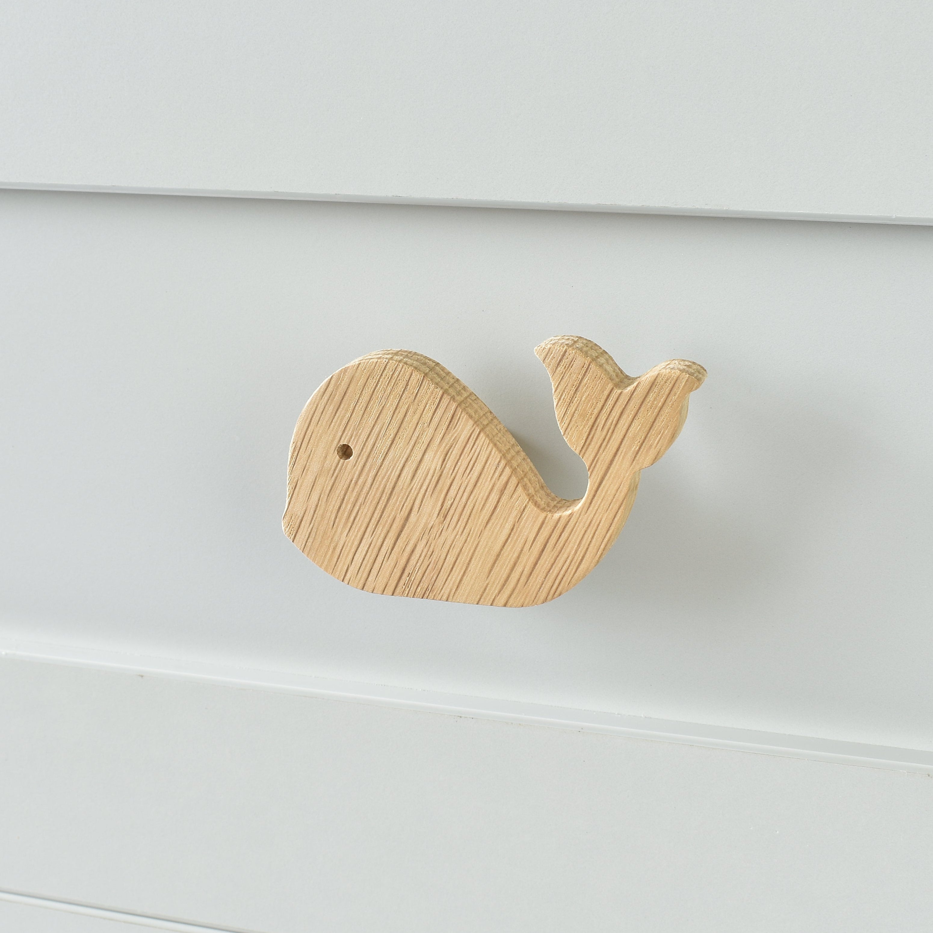 Oak whale drawer knob fitted to a white chest of drawers showing natural wood grain