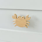 Oak crab drawer knob fitted to a white chest of drawers showing natural wood grain
