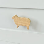 Oak sheep drawer knob fitted to a white chest of drawers showing natural wood grain