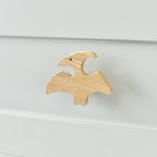 Oak pterodactyl drawer knob fitted to a white chest of drawers showing natural wood grain
