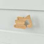 Oak excavator drawer knob fitted to a white chest of drawers showing natural wood grain