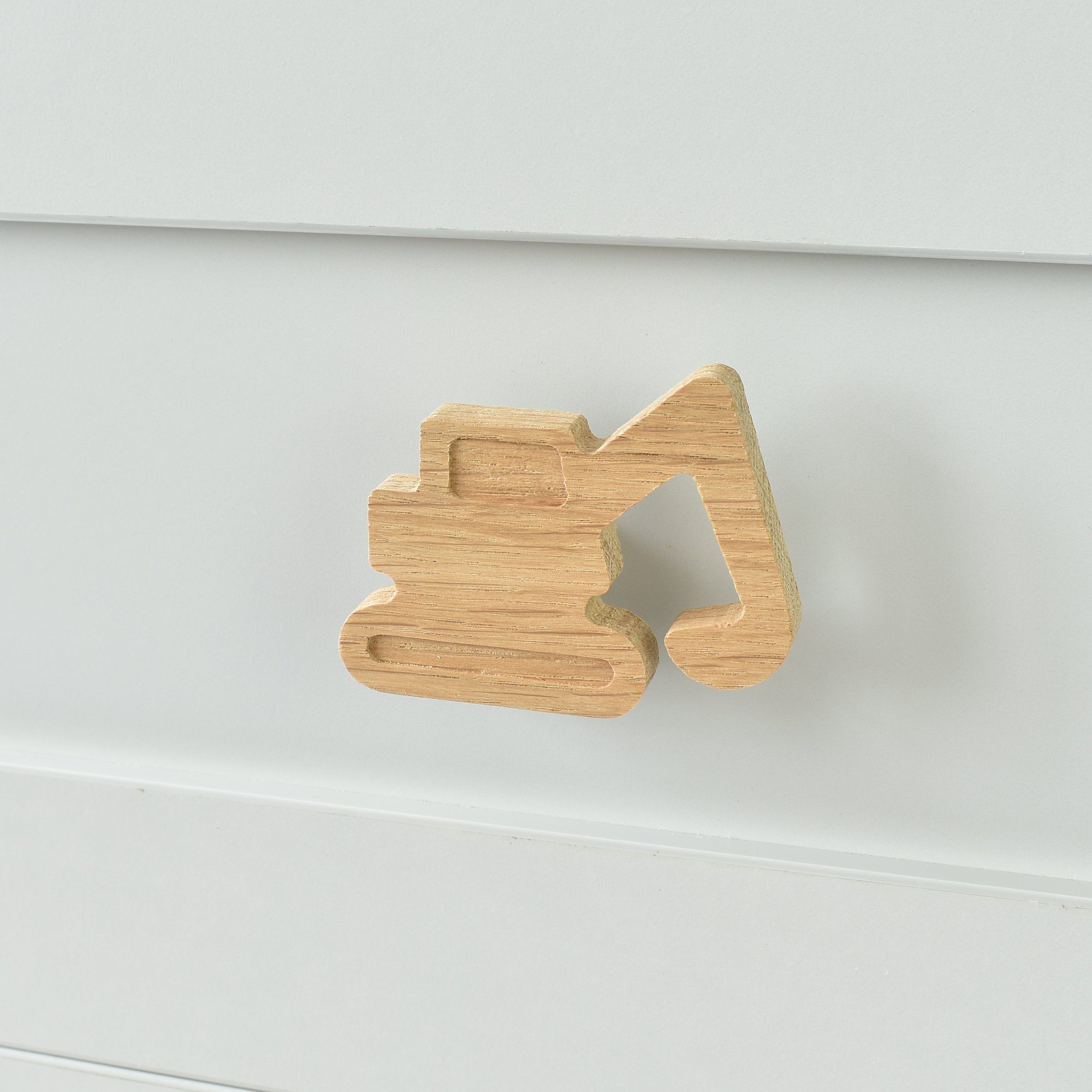 Oak excavator drawer knob fitted to a white chest of drawers showing natural wood grain
