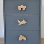 Oak transport vehicle drawer knobs fitted to a blue chest of drawers showing monster truck, aeroplane and tractor designs