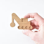 Hand holding handmade oak crane drawer knob showing raised detail and natural wood grain