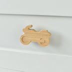 Oak motorbike drawer knob fitted to a white chest of drawers showing natural wood grain