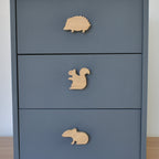 Oak woodland animal drawer knobs fitted to a blue chest of drawers showing hedgehog, squirrel and mouse designs