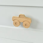 Oak monster truck drawer knob fitted to a white chest of drawers showing natural wood grain