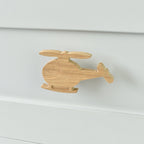 Oak helicopter drawer knob fitted to a white chest of drawers showing natural wood grain