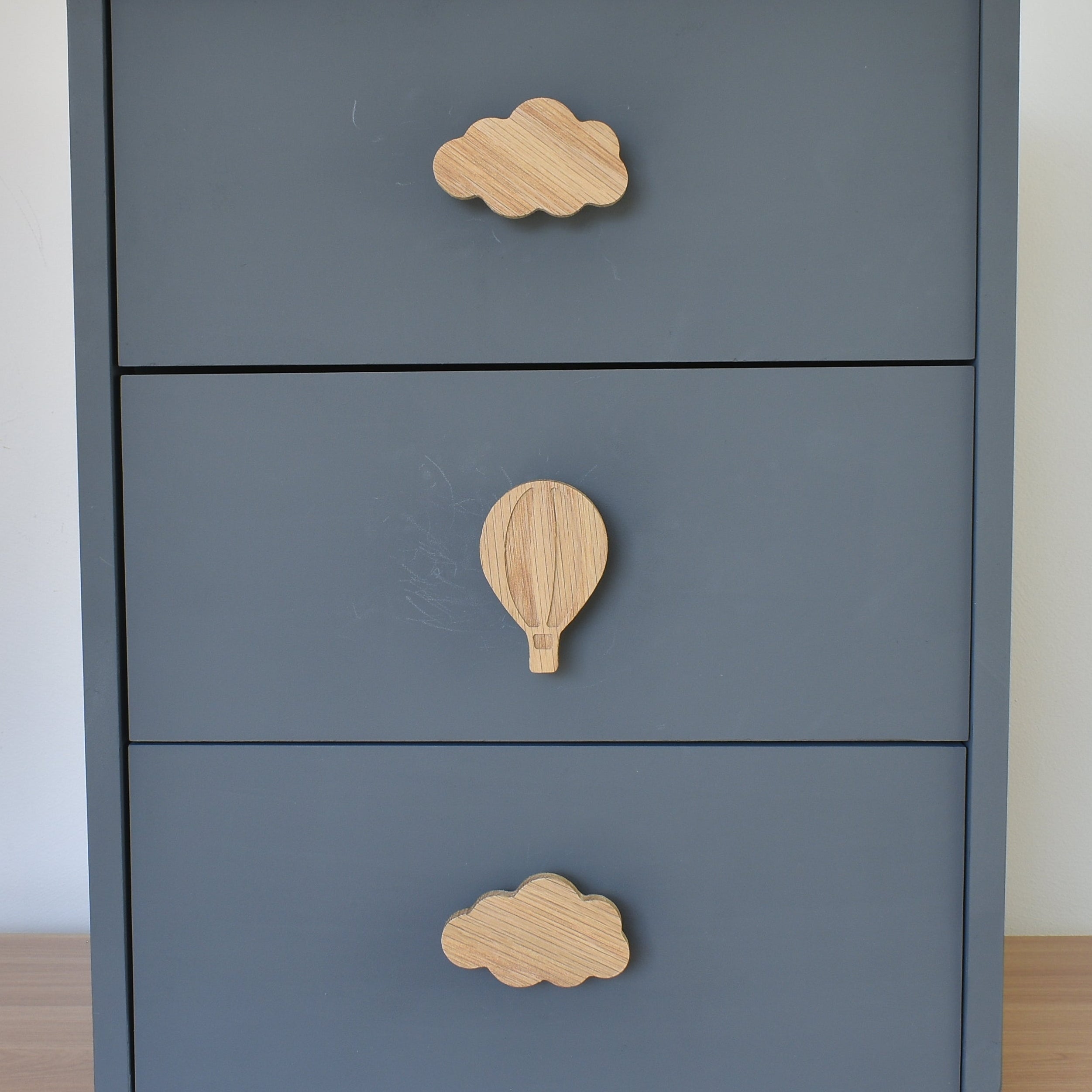 Oak cloud and hot air balloon drawer knobs fitted to a blue chest of drawers