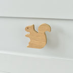 Oak squirrel drawer knob fitted to a white chest of drawers showing natural wood grain