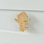 Oak astronaut drawer knob fitted to a white chest of drawers showing natural wood grain