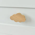 Oak cloud drawer knob fitted to a white chest of drawers showing natural wood grain