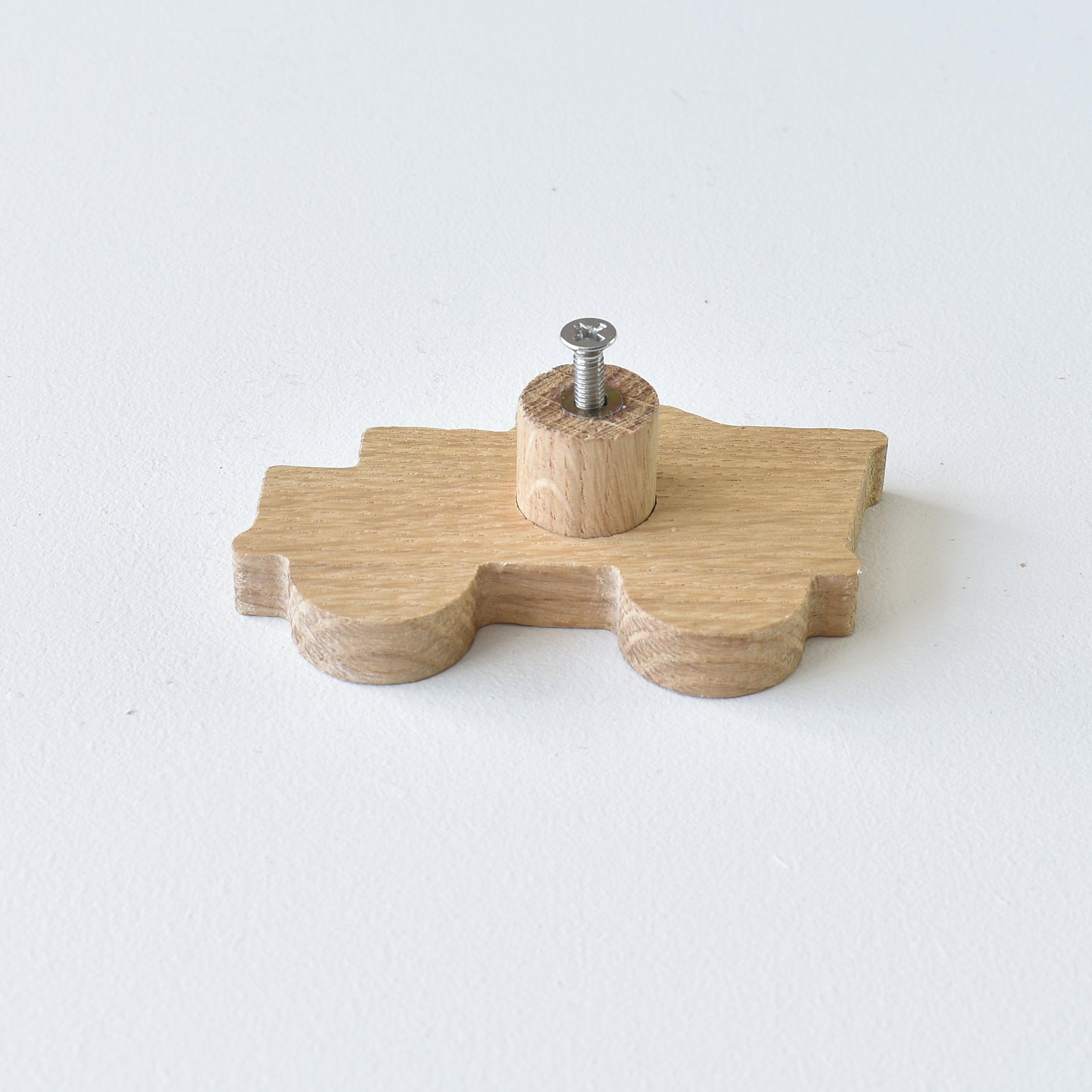 Back of oak construction vehicle drawer knob showing threaded insert and fixing screw