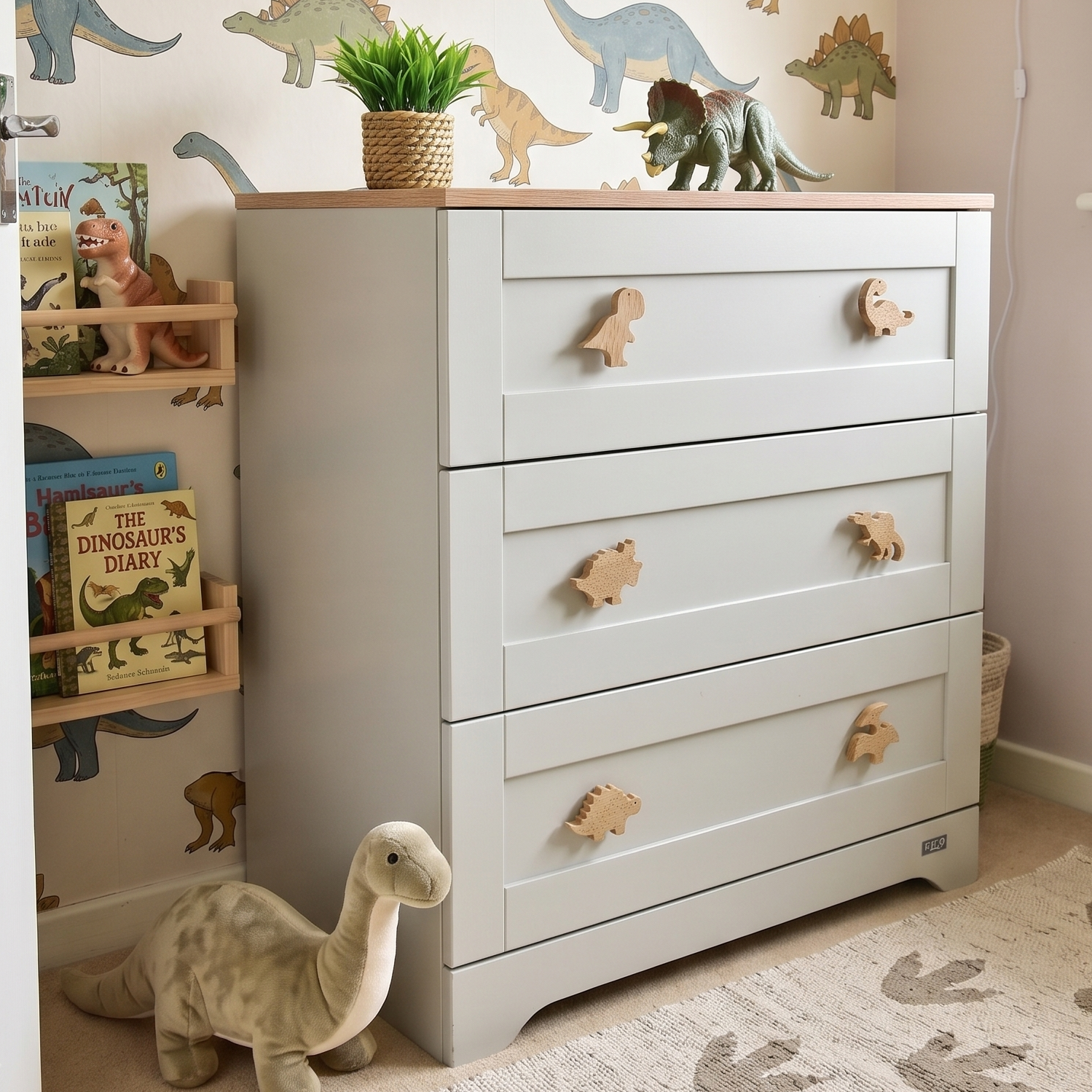 Oak dinosaur drawer knobs fitted to a white nursery chest of drawers in a children’s bedroom