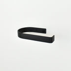 rounded edge black metal toilet roll holder with a white background 