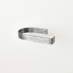 rounded edge pewter metal toilet roll holder with a white background